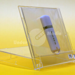 Ein weißer USB-Stick mit der Aufschrift "Edition 2015" in einer klaren Klapphülle auf einem gelben Hintergrund.