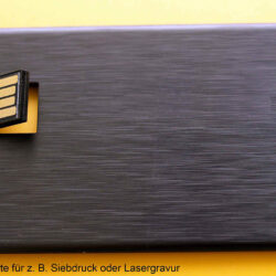 Schwarze USB-Visitenkarte mit herausziehbarem USB-Anschluss auf gelbem Hintergrund.