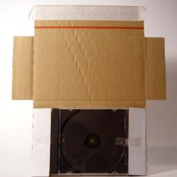 Ein Pappkarton, der eine CD-Hülle mit schwarzer Disc anzeigt, die durch eine Öffnung sichtbar ist.
