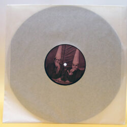 Eine Schallplatte in transparentem Umschlag mit einem runden Etikett, das zwei ältere Männer mit langen Bärten und spitzen Hüten zeigt.