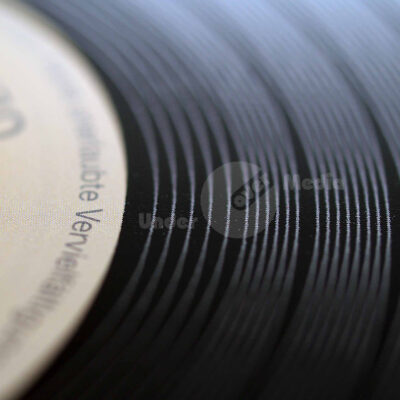 Detaillierte Aufnahme der Rillen einer Schallplatte mit Fokus auf das Label.