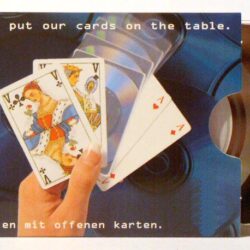 Ein Hand hält Spielkarten, während eine CD-Hülle im Hintergrund sichtbar ist.
