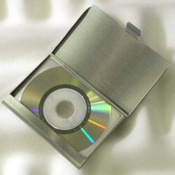 Eine silberne CD-Hülle, die eine CD mit bunten Reflexionen zeigt, auf einem weißen Hintergrund.