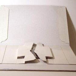 Offene Packung aus weißem Karton mit einer mechanischen Halterung in der Mitte.