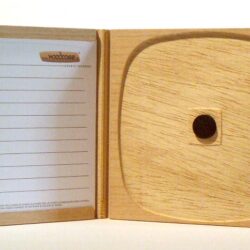 Eine geöffnete Holzschatulle mit einer Innenfläche für Speicherkarten und einem beschriftbaren Bereich auf der linken Seite.