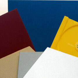 Verschiedene Ordner und Hüllen in verschiedenen Farben, darunter Rot, Blau, Gelb, Silber und Braun.