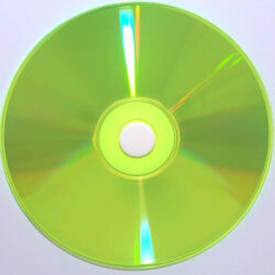 Ein kreisförmiger, transparenter CD-Rohling in leuchtendem Gelb-Grün, auf weißem Hintergrund.