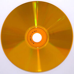 Eine orange CD, die auf einem weißen Hintergrund liegt, mit sichtbarem Loch in der Mitte.