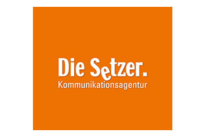 Logo der Kommunikationsagentur Die Setzer auf orangefarbenem Hintergrund.